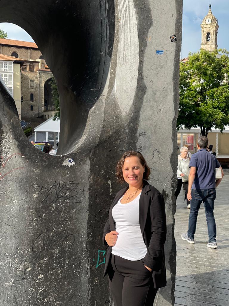 Abogada frente a escultura en la plaza